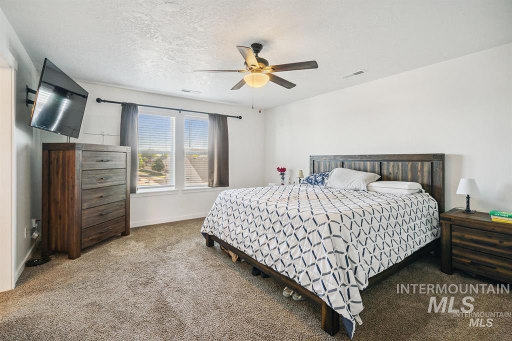 12656 Brun Street Caldwell, ID 83607 - Photo 12 of 39 Carpeted bedroom featuring a textured ceiling and ceiling fan