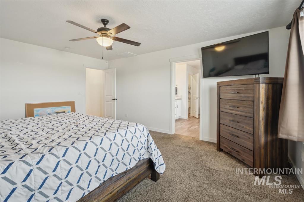 12656 Brun Street Caldwell, ID 83607 - Photo 13 of 39 Bedroom with carpet, ceiling fan, ensuite bathroom, and a textured ceiling