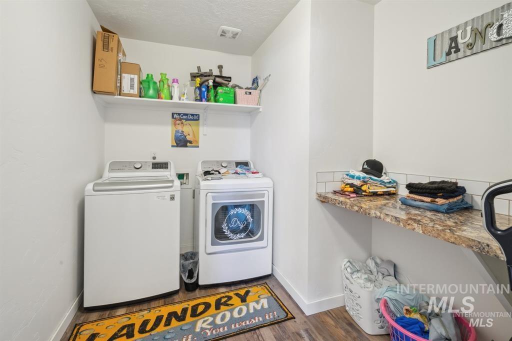 12656 Brun Street Caldwell, ID 83607 - Photo 17 of 39 Laundry area featuring a textured ceiling, dark wood-style floors, and washer and clothes dryer