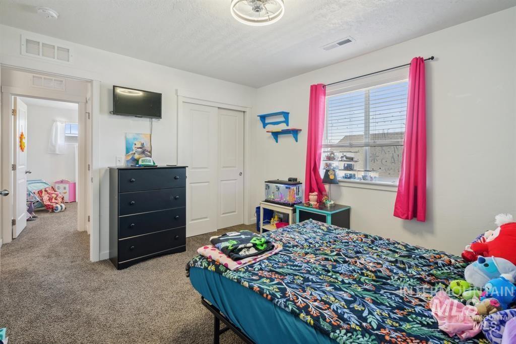 12656 Brun Street Caldwell, ID 83607 - Photo 18 of 39 Bedroom featuring light carpet, a closet, and a textured ceiling
