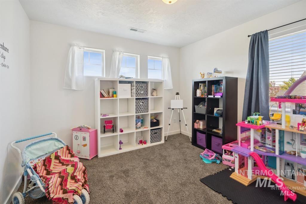 12656 Brun Street Caldwell, ID 83607 - Photo 25 of 39 Playroom featuring dark carpet and a textured ceiling