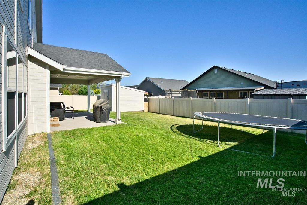 12656 Brun Street Caldwell, ID 83607 - Photo 30 of 39 Fenced backyard featuring a trampoline, a patio area, and a shed
