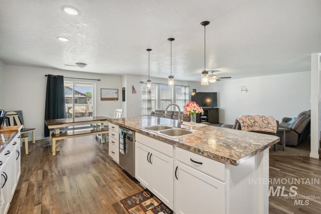 12656 Brun Street Caldwell, ID 83607 - Photo 39 of 39 Kitchen featuring white cabinets, open floor plan, dark wood-style floors, and decorative light fixtures