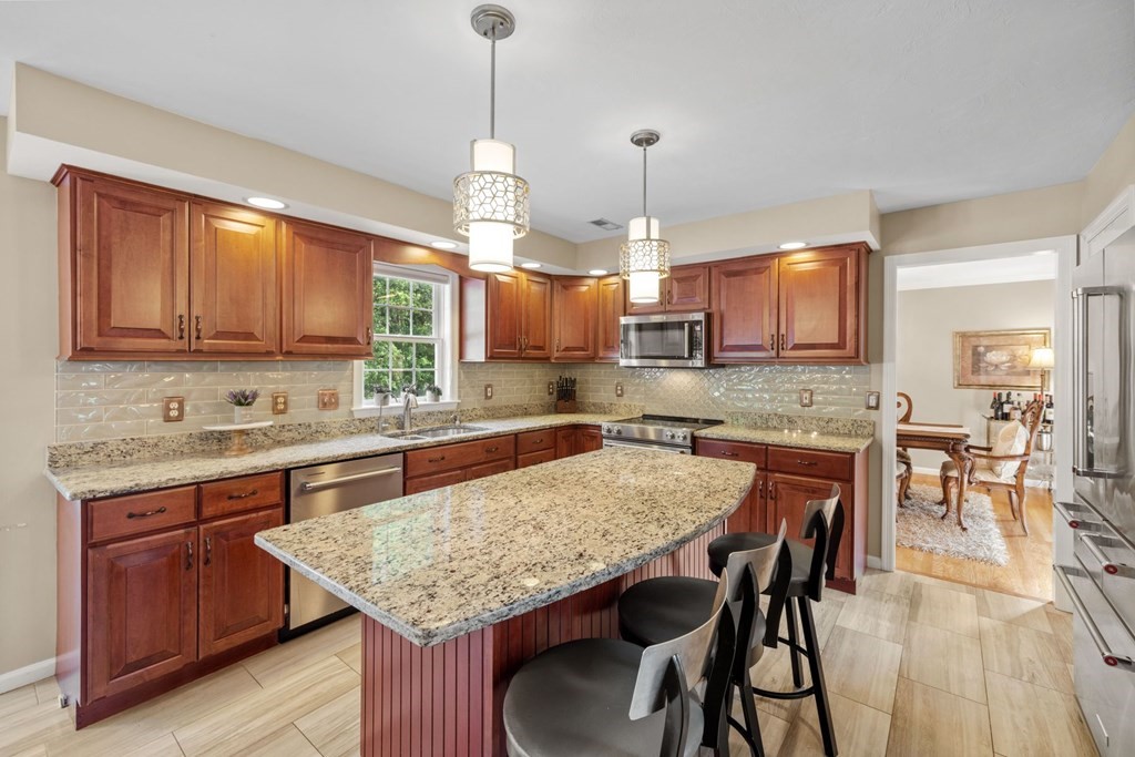 17 Amherst Road Shrewsbury, MA 01545 - Photo 11 of 42 a kitchen with granite countertop kitchen island a table and chairs in it