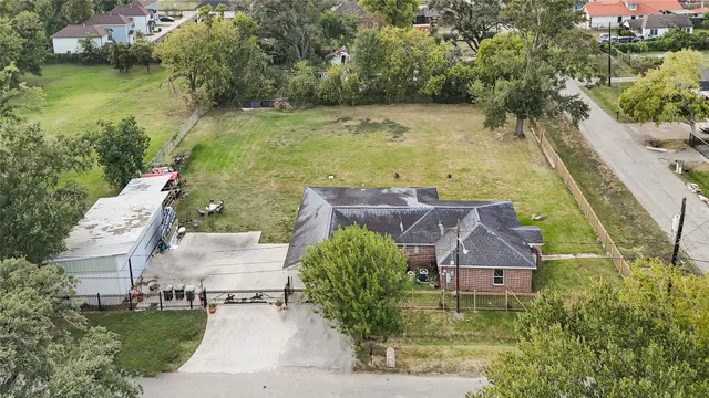 an aerial view of a house with a yard and lake view