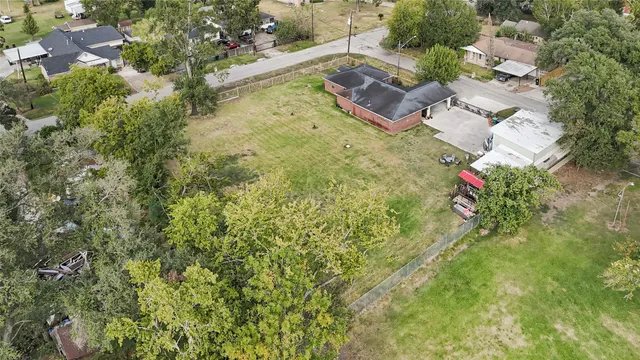 an aerial view of residential house with outdoor space and trees all around