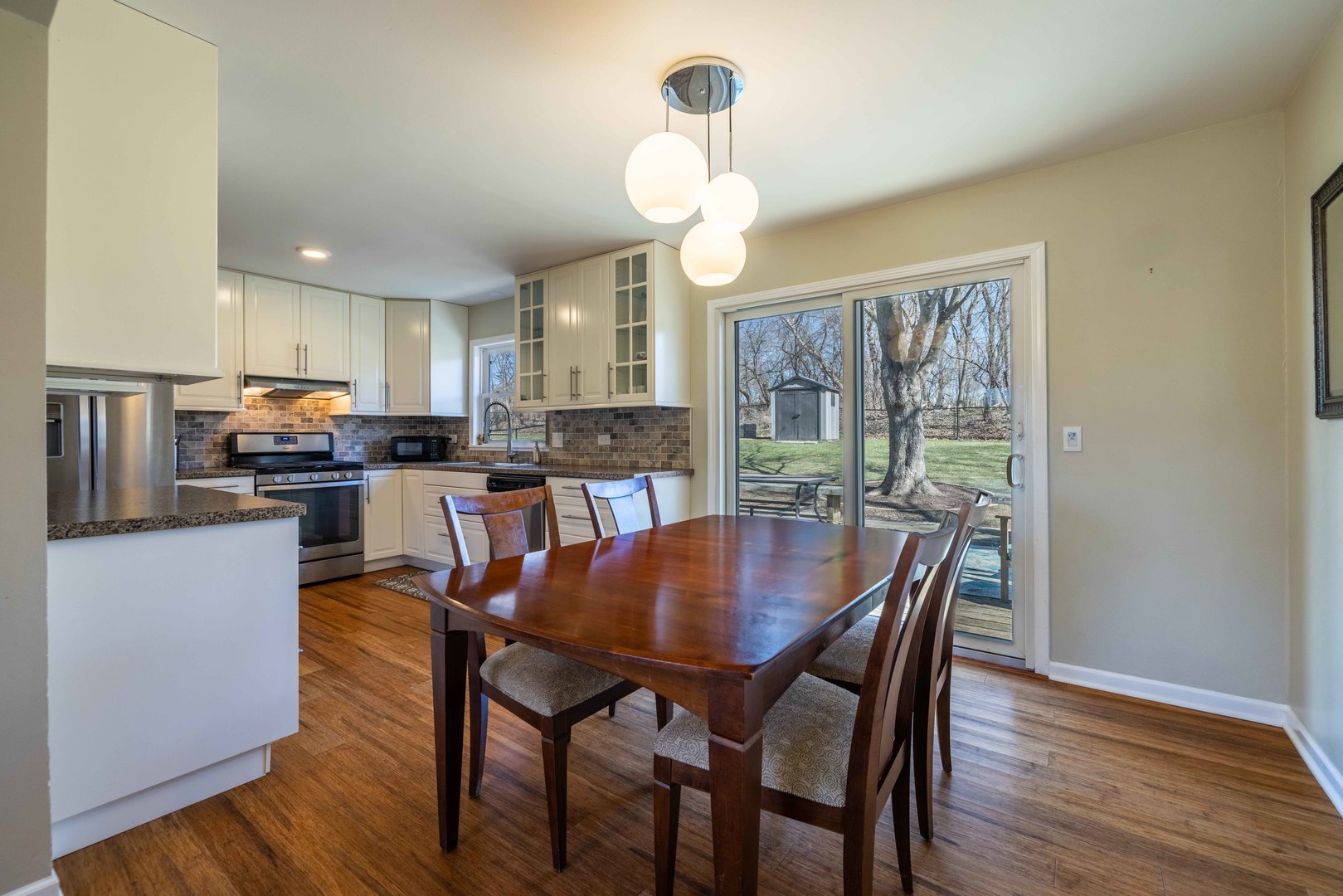 619 Scott Street Algonquin, IL 60102 - Photo 11 of 48 a dining room with wooden floor a chandelier a wooden table and chairs