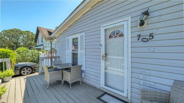 a view of a deck with chair and table and wooden floor