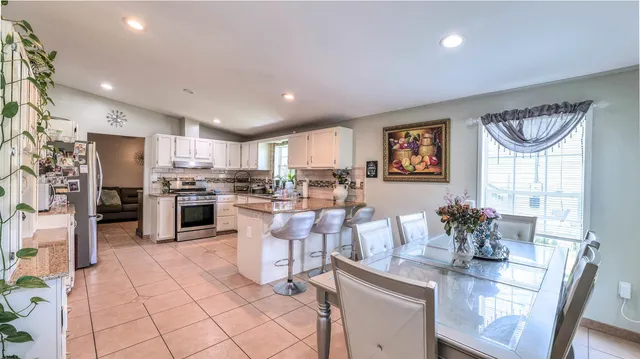 a kitchen with stainless steel appliances granite countertop a refrigerator and a stove top oven