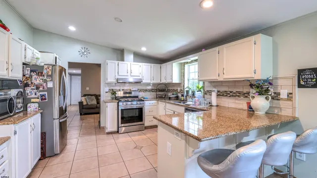 a kitchen with stainless steel appliances granite countertop a stove refrigerator sink and cabinets