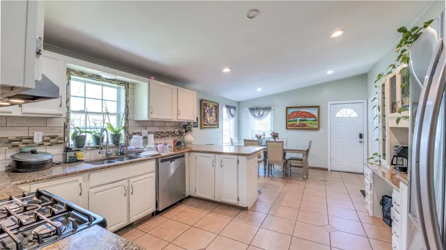 a kitchen with stainless steel appliances granite countertop a refrigerator and a sink