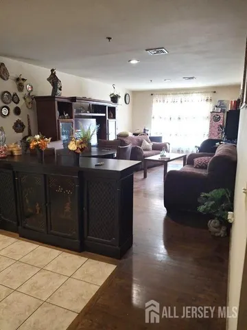 a kitchen with stainless steel appliances granite countertop a sink dishwasher stove and couches with wooden floor