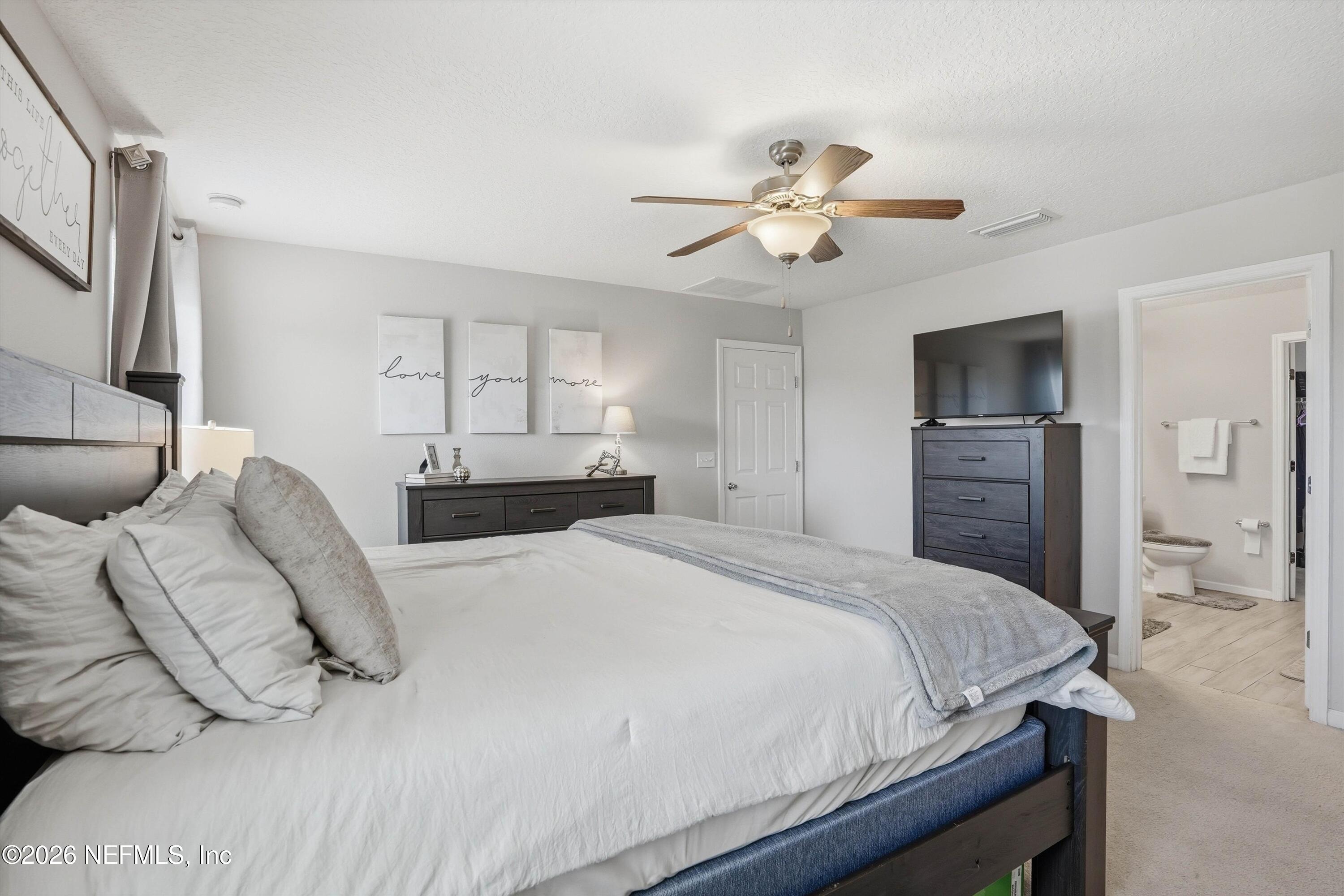 29 Auburn Oaks Road West Jacksonville, FL 32218 - Photo 12 of 38 a bedroom with a bed and a chandelier