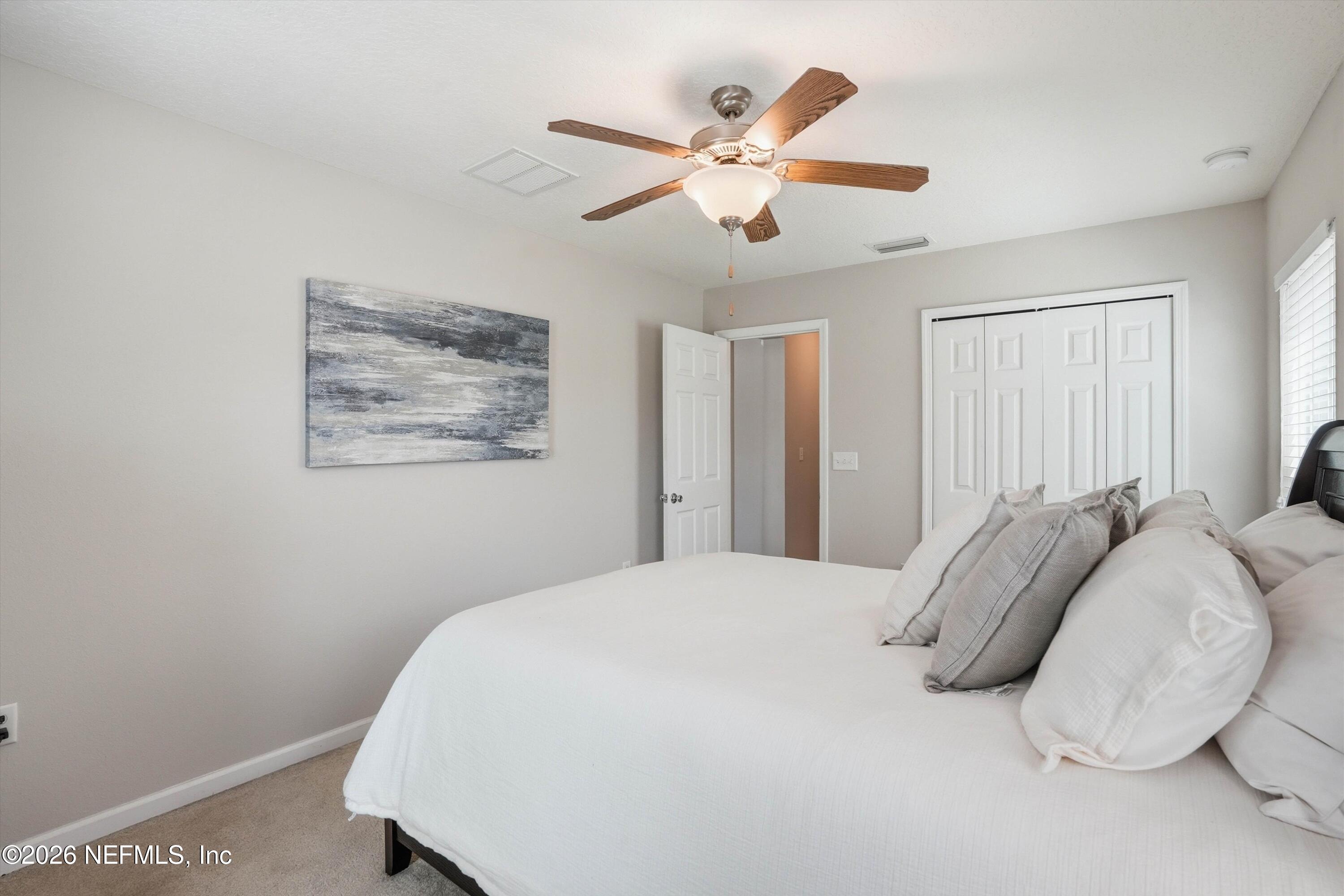29 Auburn Oaks Road West Jacksonville, FL 32218 - Photo 16 of 38 a bedroom with a large bed and a chandelier