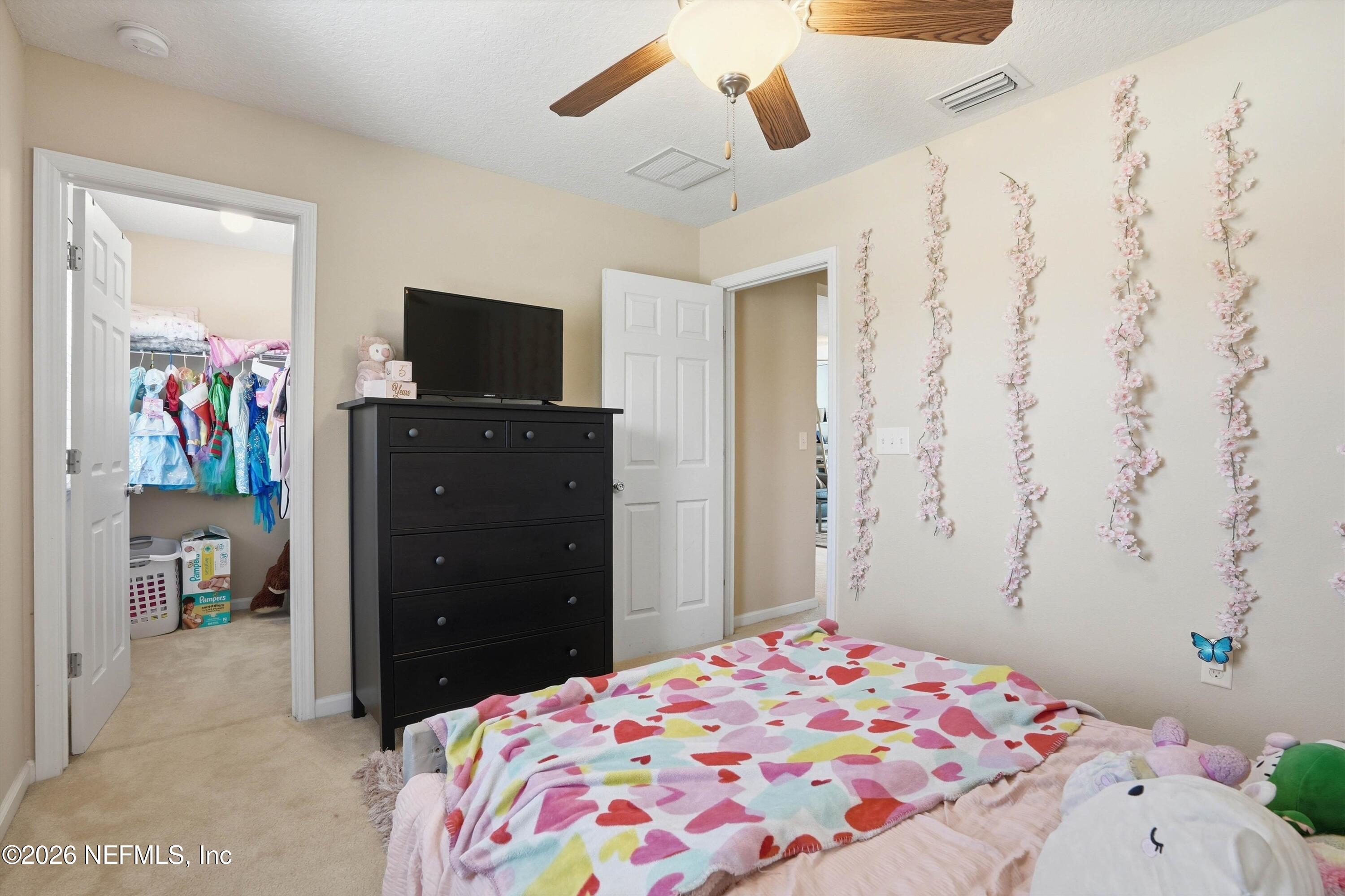 29 Auburn Oaks Road West Jacksonville, FL 32218 - Photo 21 of 38 a bedroom with a bed and a flat tv screen on dresser