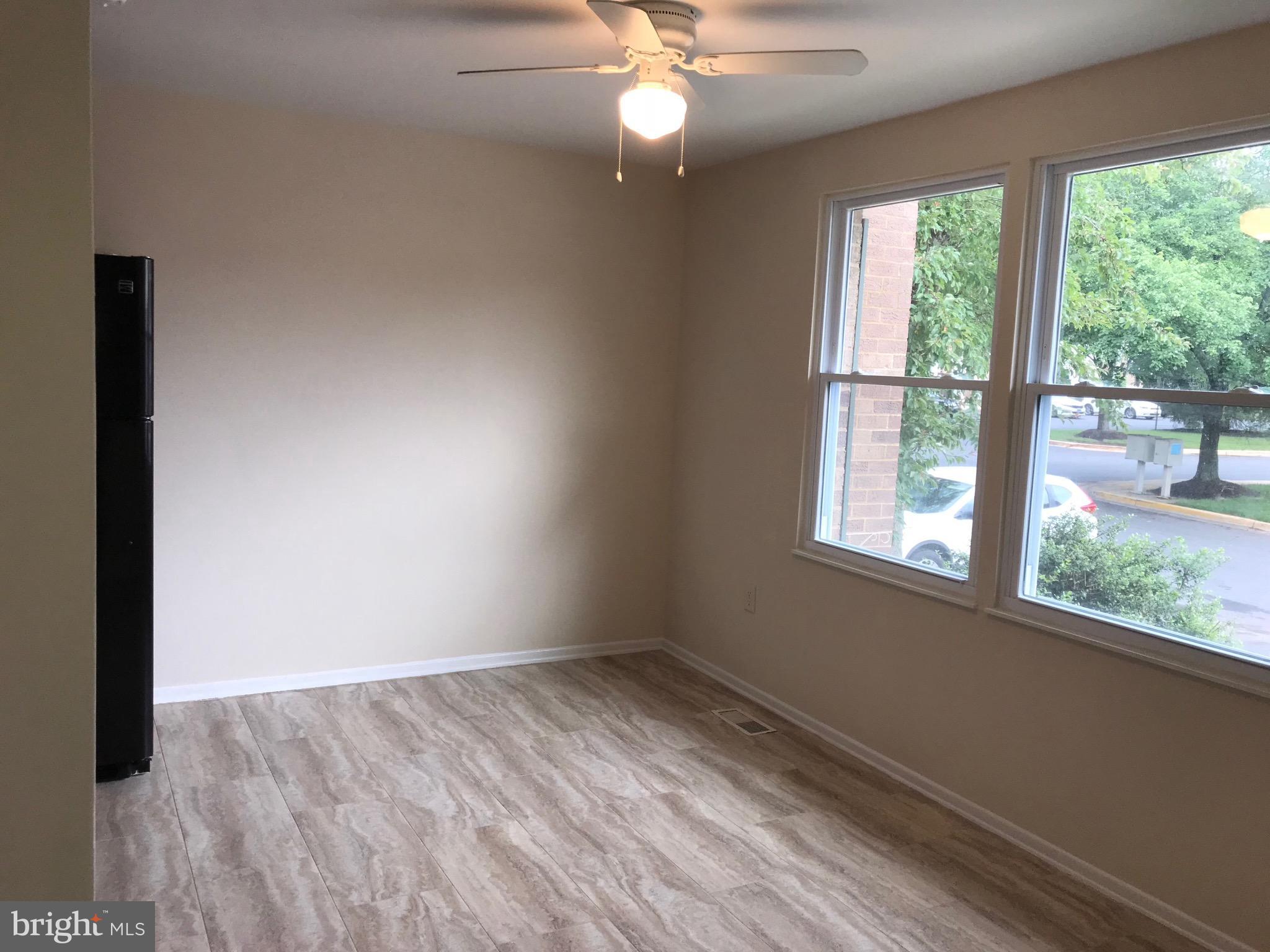 17553 Kohlhoss Road Poolesville, MD 20837 - Photo 3 of 17 an empty room with wooden floor fan and windows