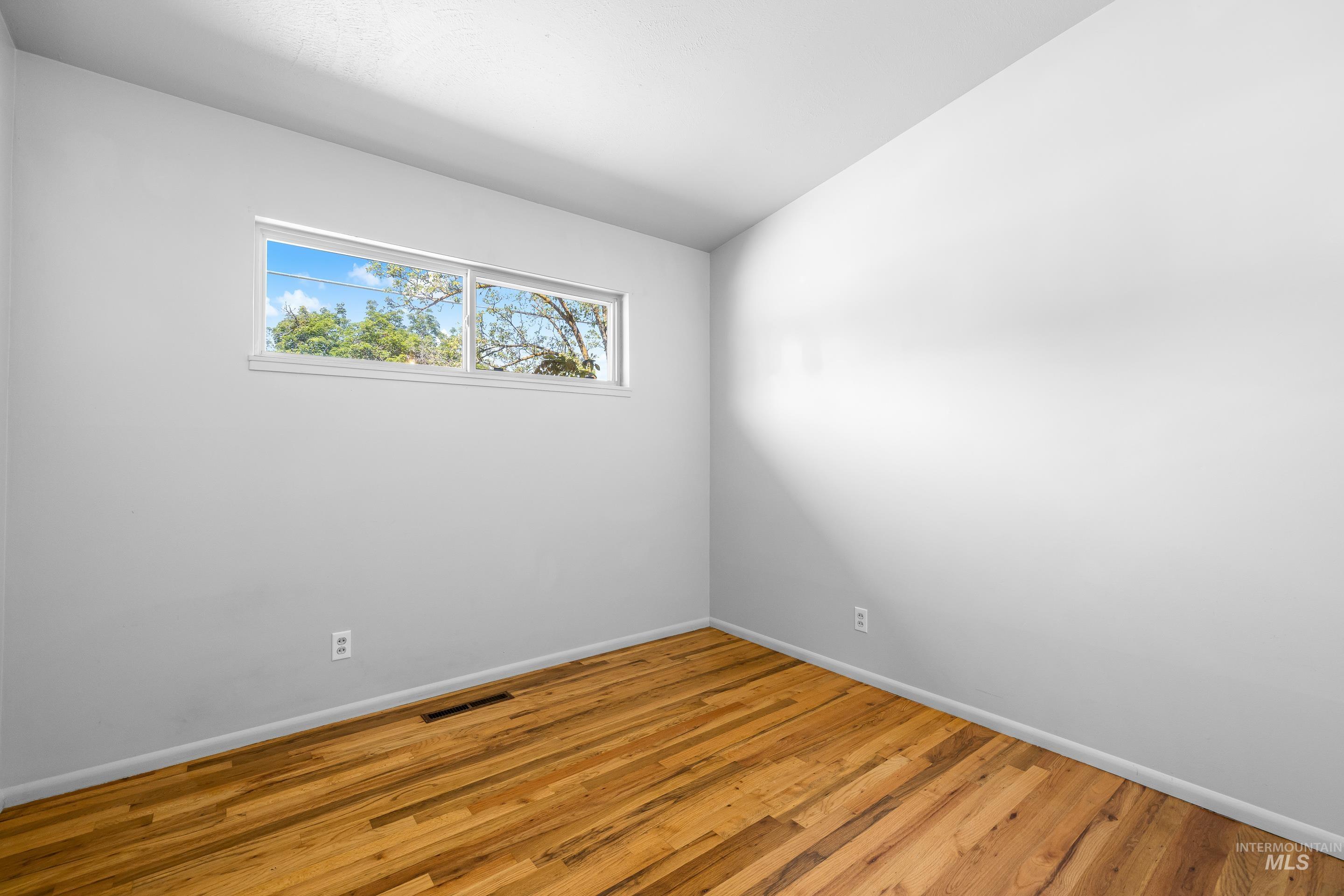 708 South Phillippi Street Boise, ID 83705 - Photo 15 of 25 Interior room featuring hardwood flooring, white walls, and a horizontal window