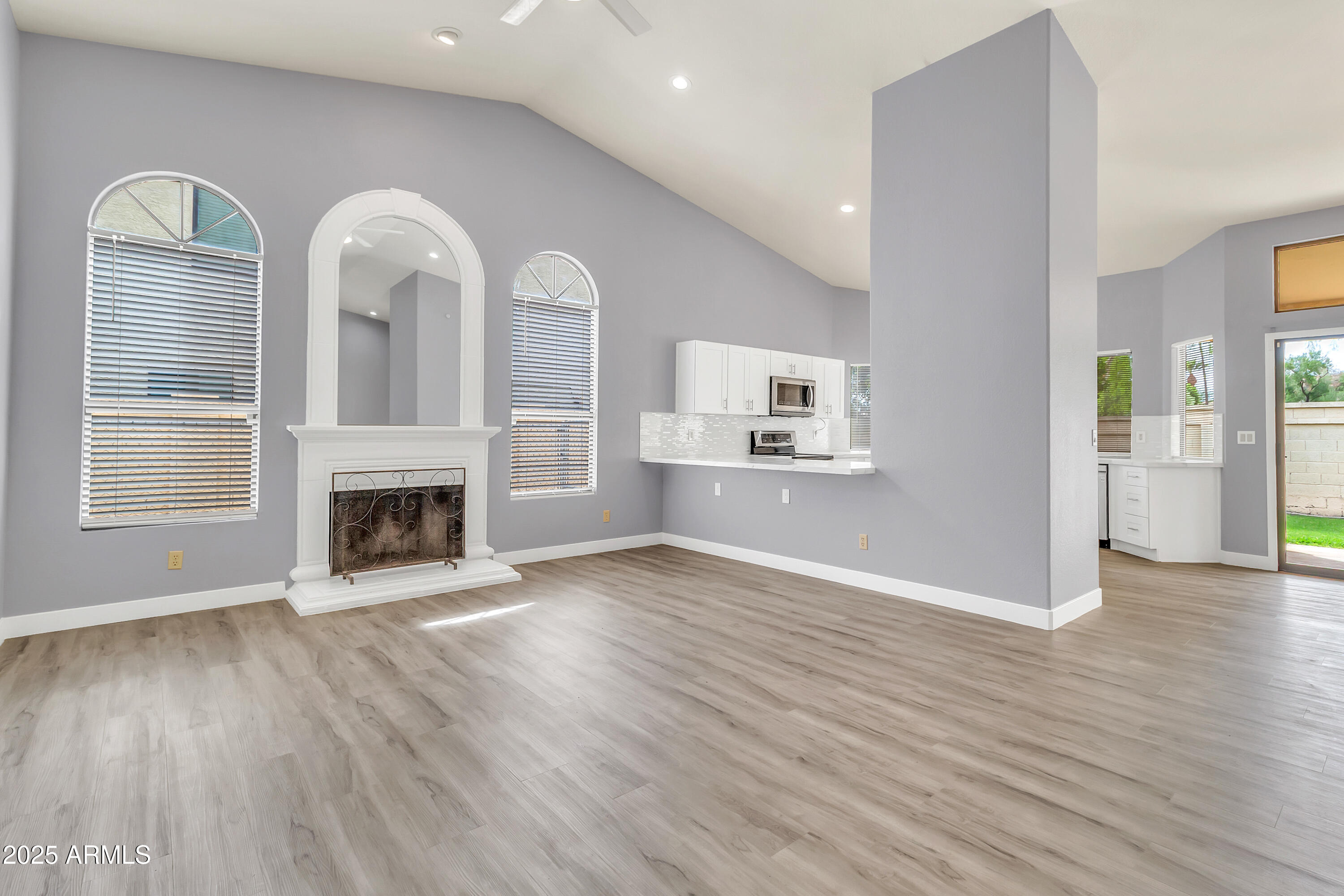 205 East Stacey Lane Tempe, AZ 85284 - Photo 2 of 63 an empty room with wooden floor fireplace and windows