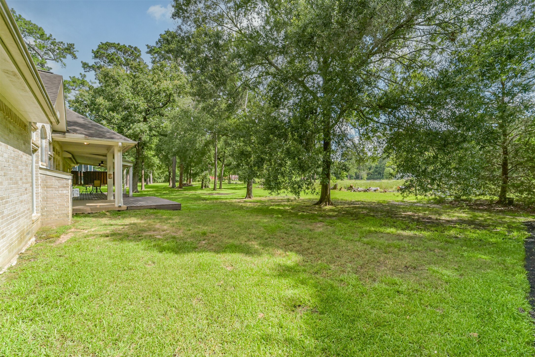 27322 Afton Way Huffman, TX 77336 - Photo 46 of 50 Expansive backyard retreat with towering trees and endless possibilities for recreation, gardening, or future pool plans.