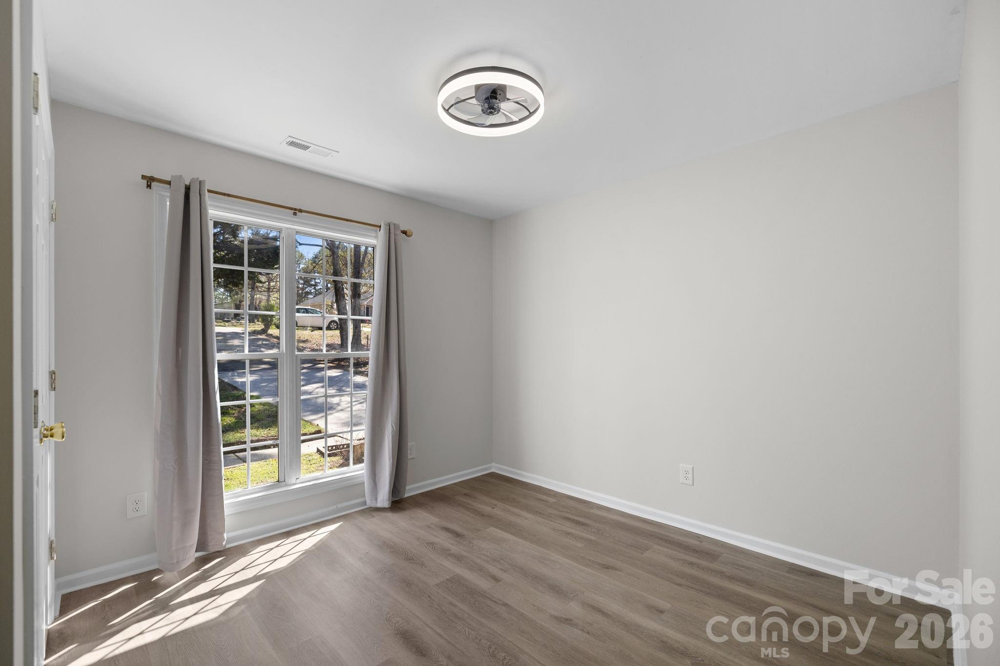1012 Crescent Way Wingate, NC 28174 - Photo 13 of 20 an empty room with wooden floor and windows
