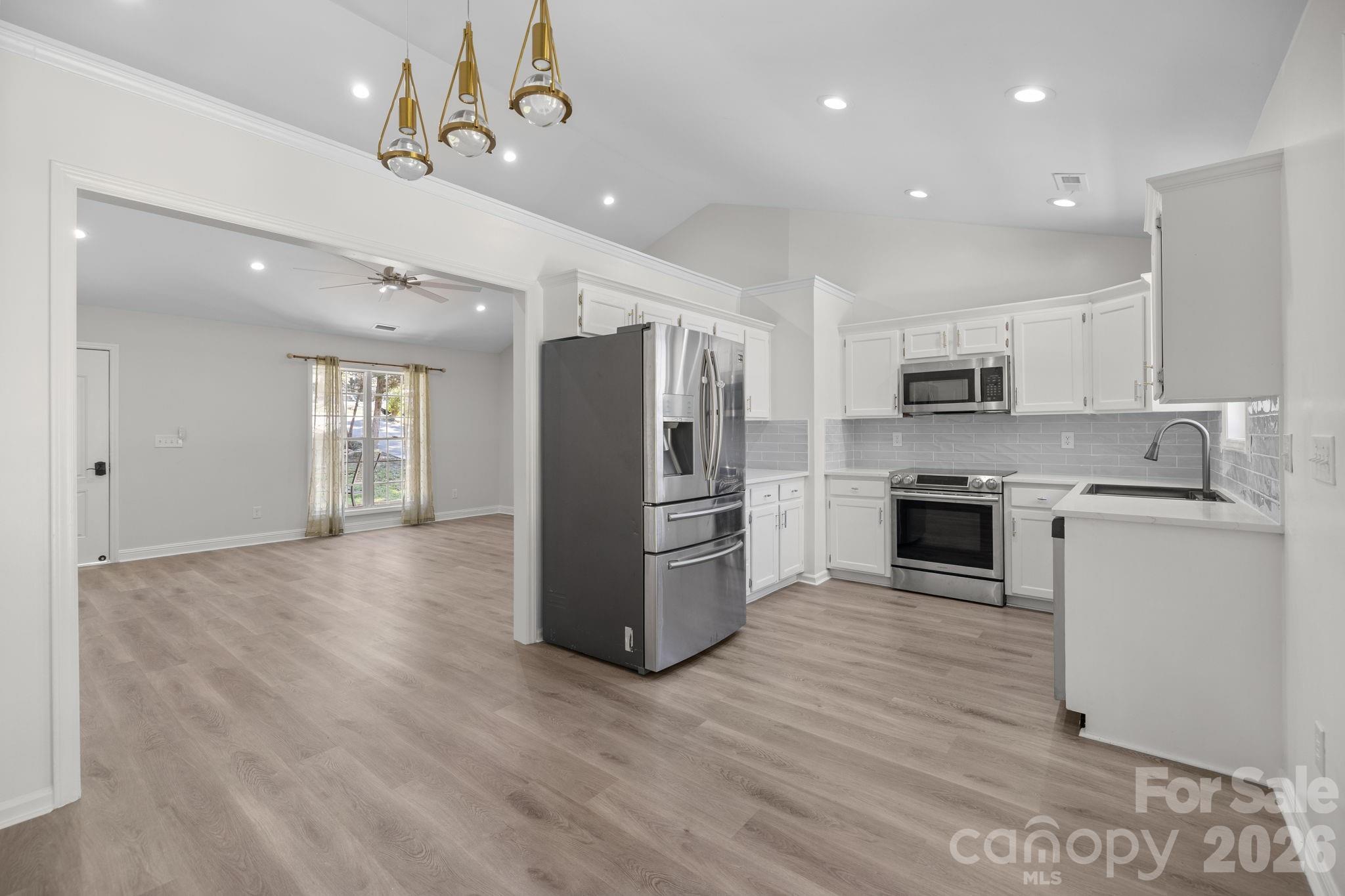 1012 Crescent Way Wingate, NC 28174 - Photo 6 of 20 a kitchen with a refrigerator a sink and a stove top oven