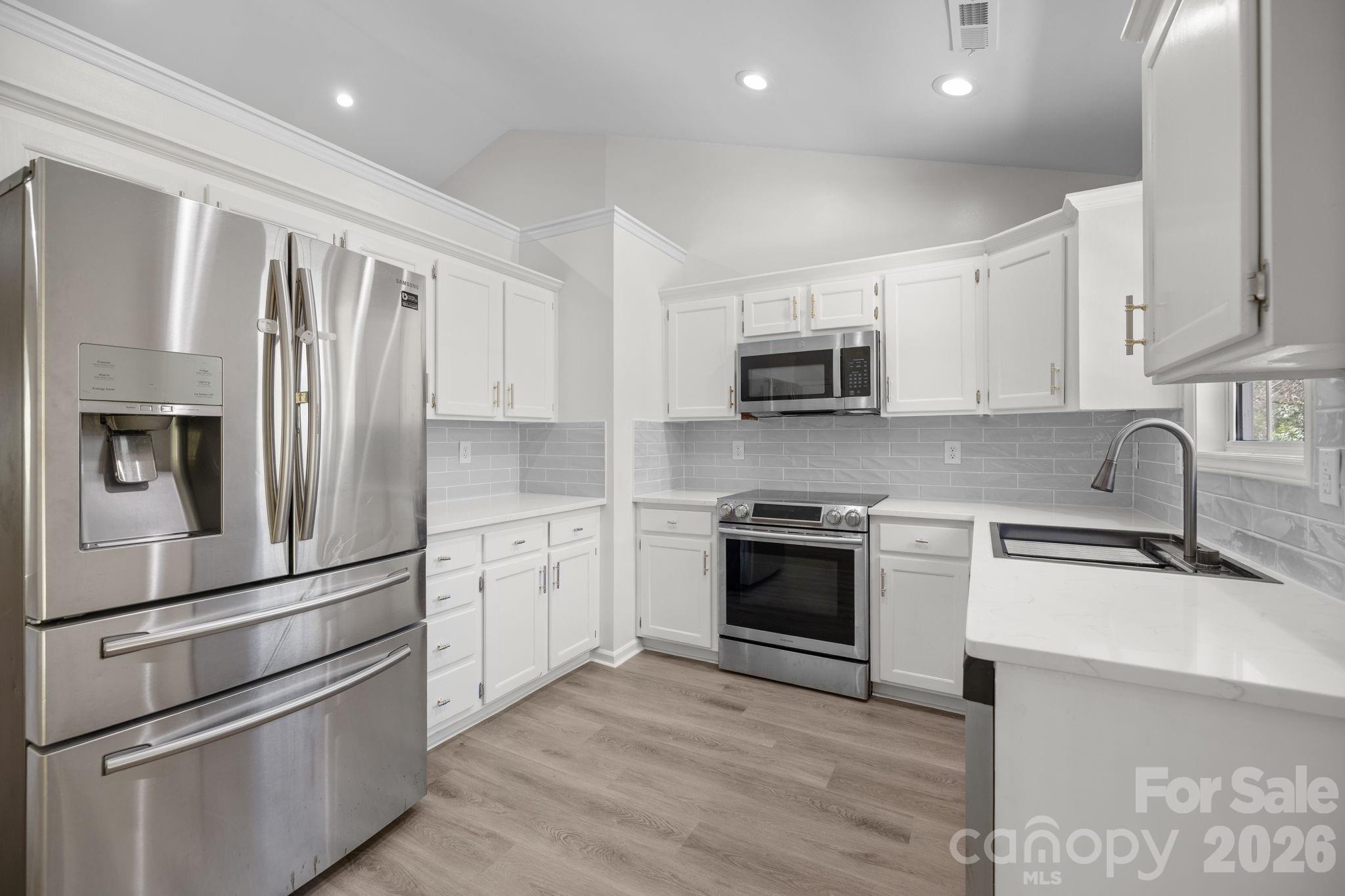 1012 Crescent Way Wingate, NC 28174 - Photo 7 of 20 a kitchen with stainless steel appliances and wooden cabinets