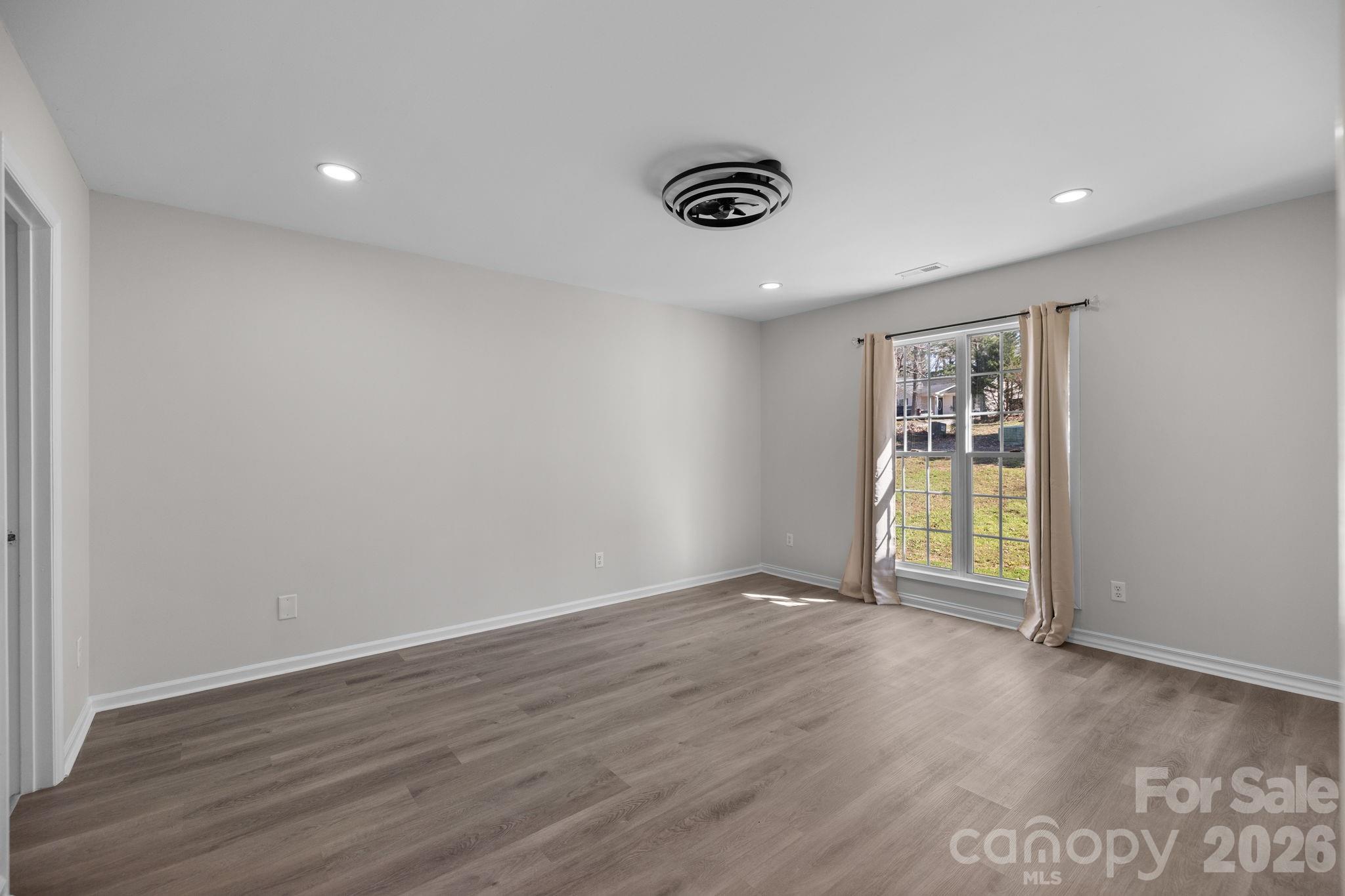 1012 Crescent Way Wingate, NC 28174 - Photo 9 of 20 an empty room with wooden floor and windows