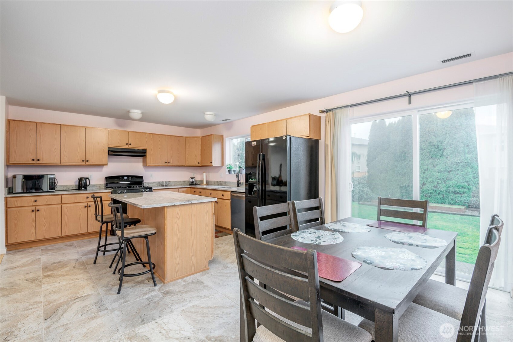 17008 Southeast 183rd Place Renton, WA 98058 - Photo 11 of 27 a kitchen with a refrigerator a stove a sink dishwasher with a dining table and chairs with outer view