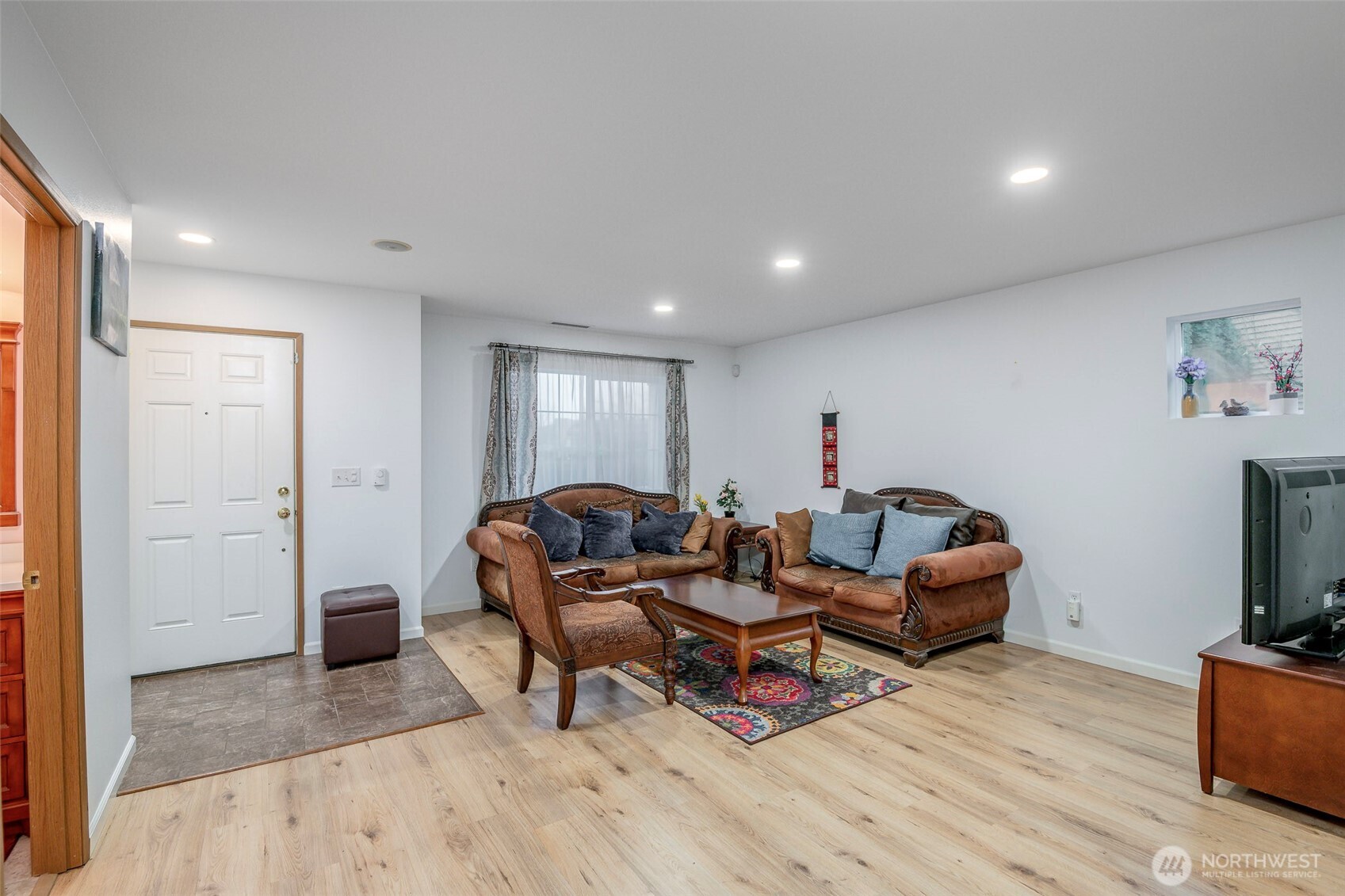 17008 Southeast 183rd Place Renton, WA 98058 - Photo 5 of 27 a living room with furniture a flat screen tv and a refrigerator