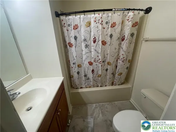 a bathroom with a granite countertop sink toilet and a shower