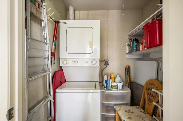 a utility room with dryer washer and a view of living room