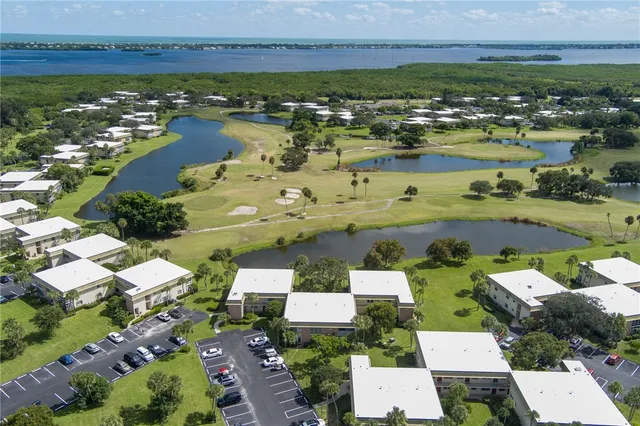 an aerial view of ocean and residential houses with outdoor space