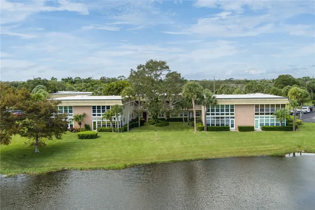 a view of a house with a big yard and large trees