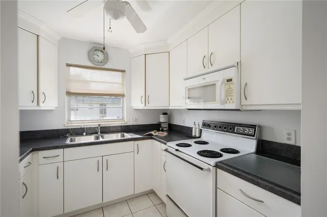 a kitchen with cabinets appliances a sink and a window