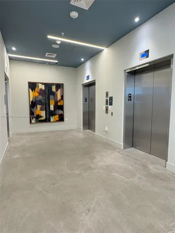 an empty room with a mirror and a ceiling fan