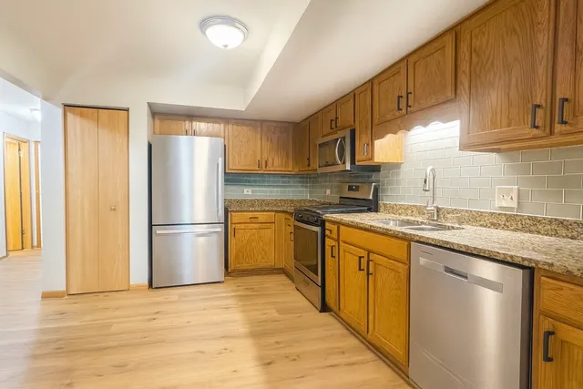 a kitchen with a refrigerator sink and cabinets
