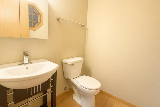 a bathroom with a sink a toilet and mirror