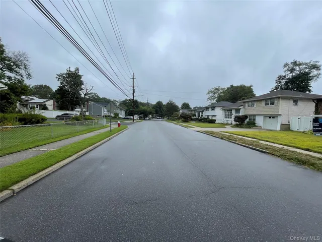 a view of a street with a building and couple of cars parked in front of it
