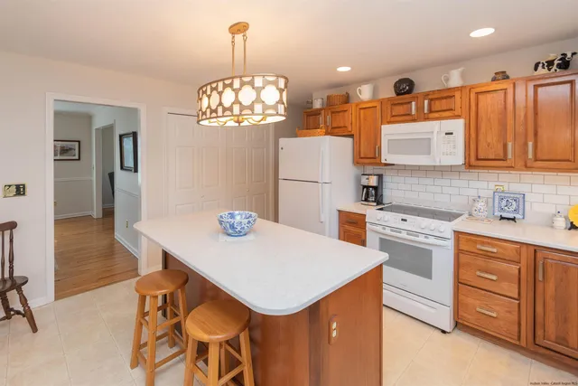 a kitchen with stainless steel appliances a table chairs and chandelier