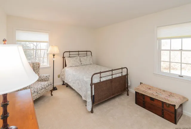 a bedroom with a bed lamp and a large window