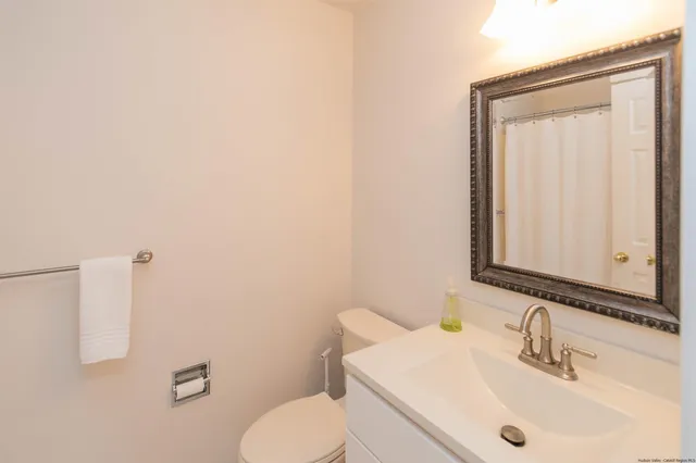 a bathroom with a sink a toilet and mirror