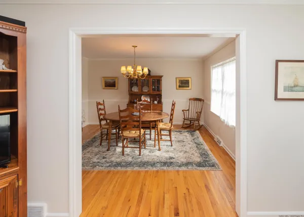 a view of a dining room with furniture a chandelier and wooden floor