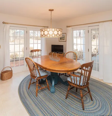 a dining room with furniture a chandelier and wooden floor
