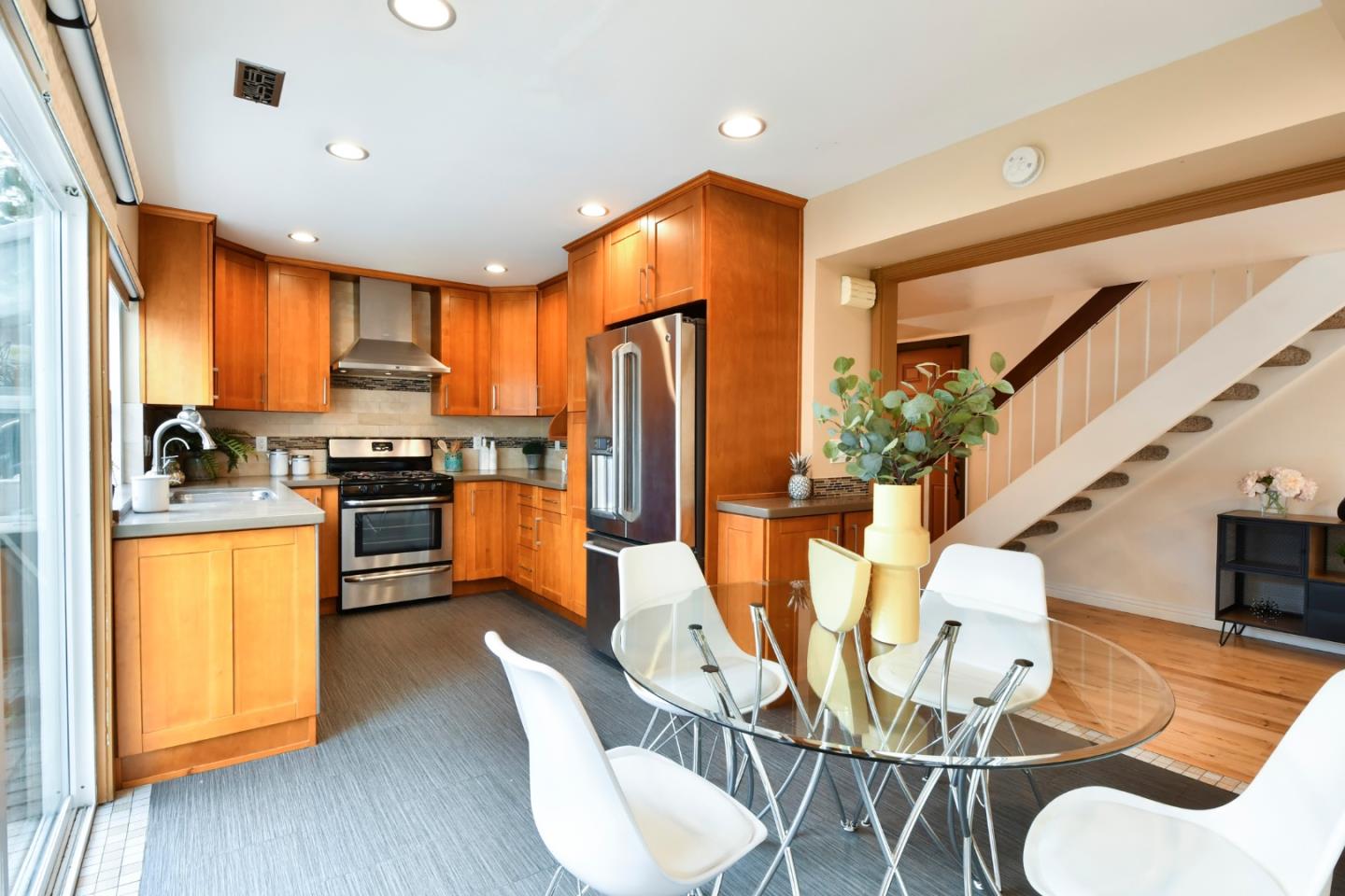22059 McClellan Road Cupertino, CA 95014 - Photo 14 of 40 a kitchen with stainless steel appliances kitchen island granite countertop a refrigerator a stove a sink dishwasher and a dining table with wooden floor
