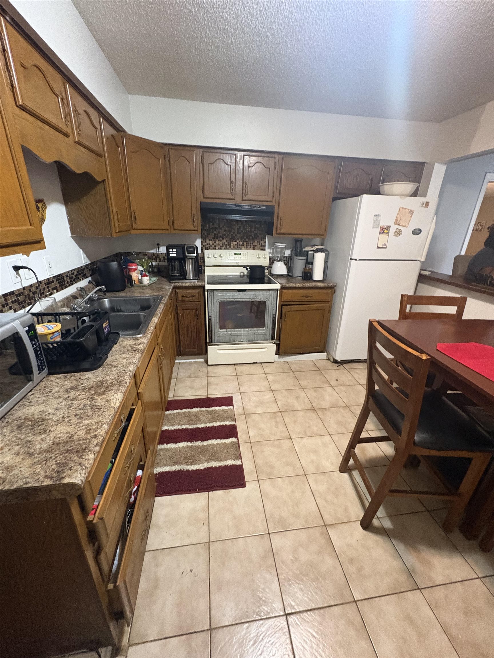 4585 Double Tree Street Memphis, TN 38109 - Photo 10 of 10 Kitchen featuring wood cabinetry, a tiled backsplash, and light-toned tile flooring