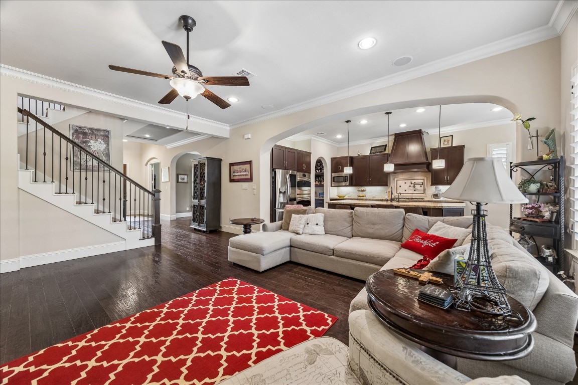 3 Tiburon Court Spring, TX 77389 - Photo 35 of 35 This inviting living area features an open floor plan seamlessly connecting to a modern kitchen with pendant lighting and dark cabinetry, offering a comfortable and functional layout for entertaining or relaxing.