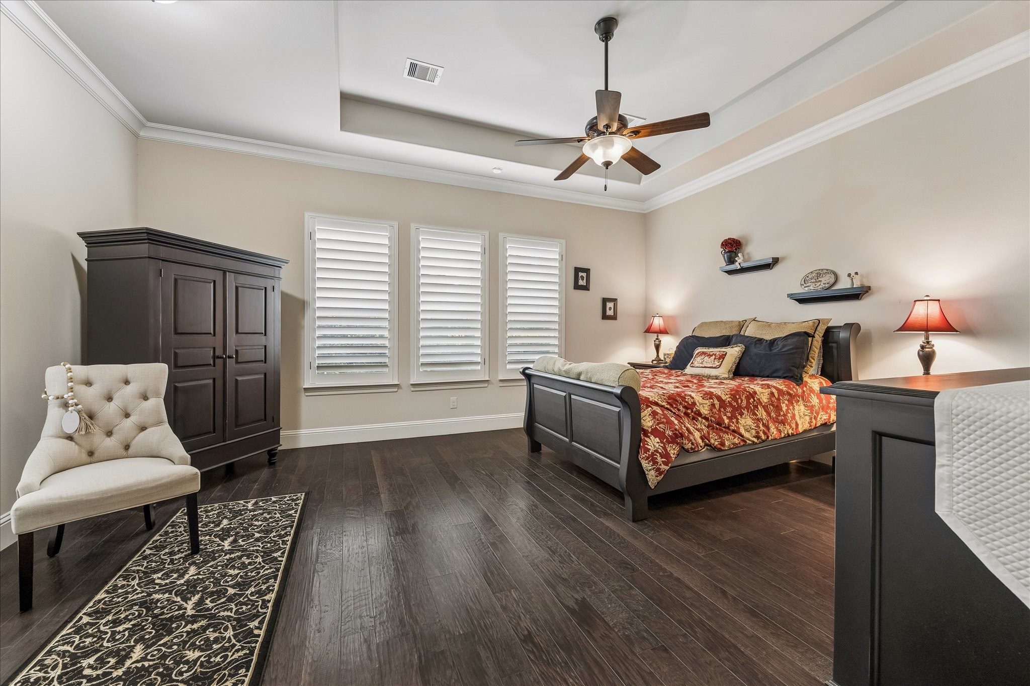 3 Tiburon Court Spring, TX 77389 - Photo 15 of 37 This spacious primary suite features dark hardwood floors, a tray ceiling with a fan, and ample natural light.