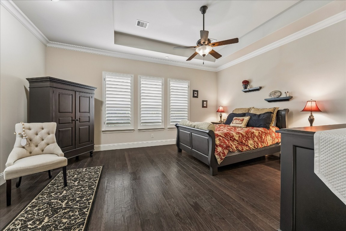 3 Tiburon Court Spring, TX 77389 - Photo 15 of 35 This spacious primary suite features dark hardwood floors, a tray ceiling with a fan, and ample natural light.