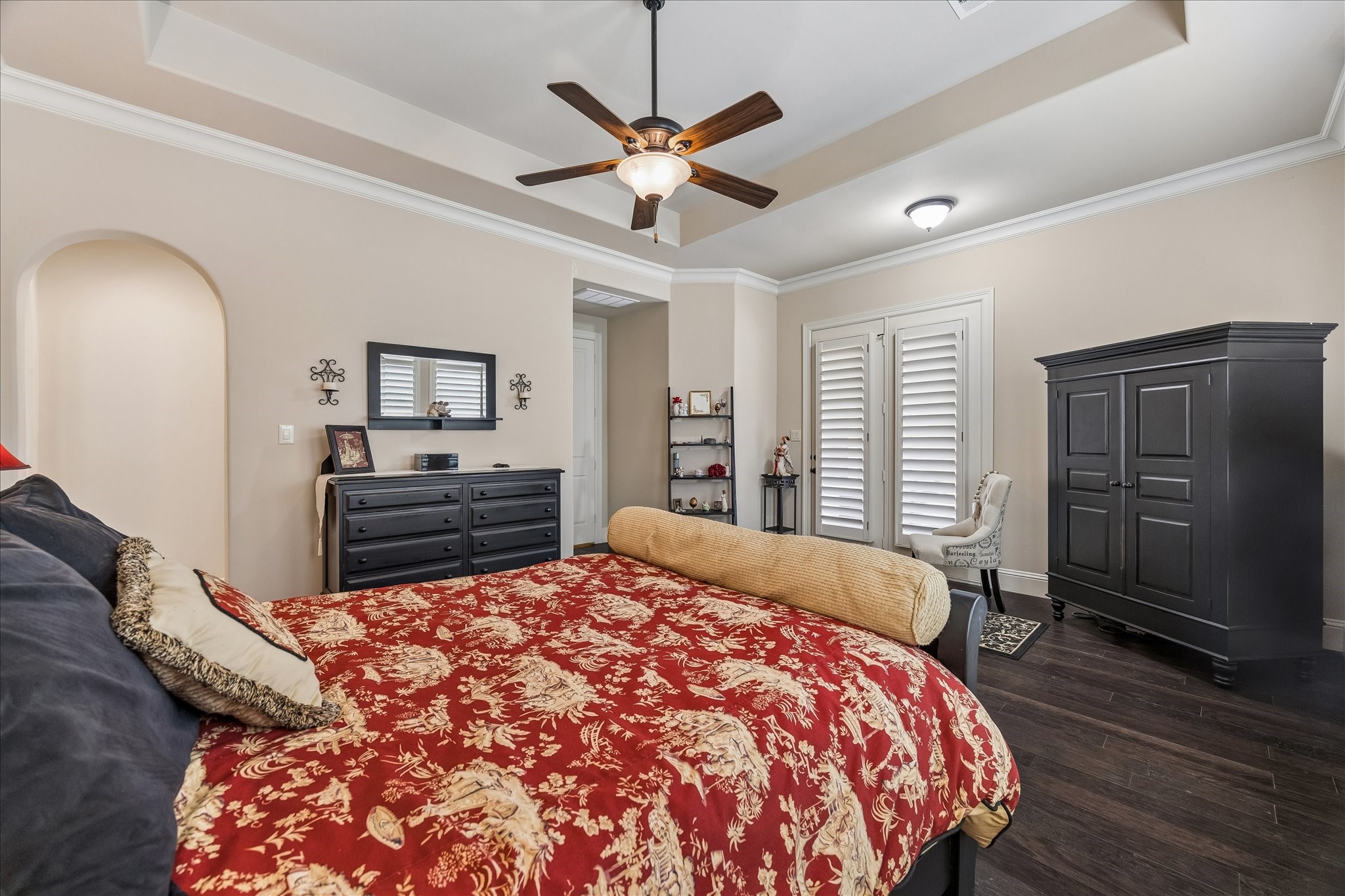 3 Tiburon Court Spring, TX 77389 - Photo 16 of 37 This inviting primary suite features a warm color palette with elegant crown molding and dark wood floors with access to backyard through double doors.