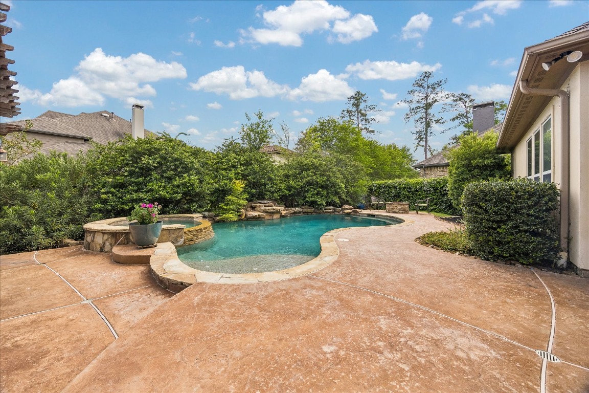 3 Tiburon Court Spring, TX 77389 - Photo 2 of 35 This inviting backyard features a beautifully landscaped pool area with a spa, surrounded by lush greenery for privacy. The spacious patio offers ample room for outdoor entertaining.